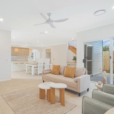 image by constructionplus_brisbane containing living room, ceiling fan, couch, kitchen, furniture